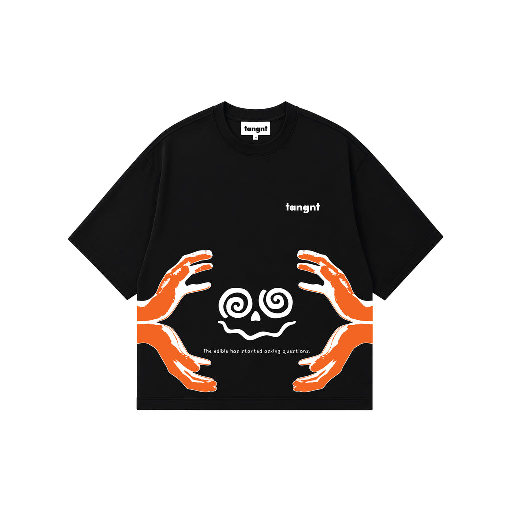 A black short-sleeve t-shirt with a graphic design featuring two orange hands reaching toward white spiral shaped face, with the text saying "the edibles has started asking questions" and brand name 'tangnt' printed on the chest.