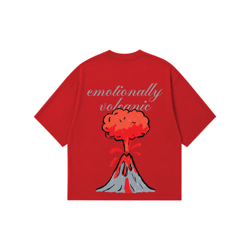 A red short-sleeve t-shirt with a graphic of an erupting volcano and the text 'emotionally volcanic' in grey script, displayed on a solid white background.