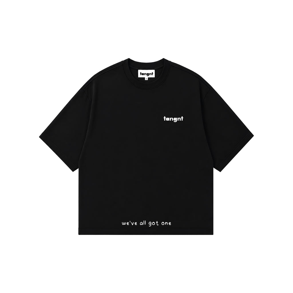 A black short-sleeve t-shirt with white text, featuring the brand name 'tangnt' on the left chest and 'we've all got one' printed near the bottom hem, displayed on a solid white background.